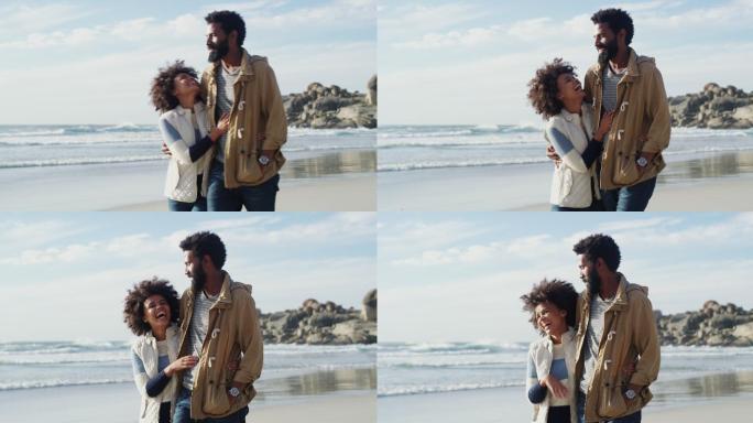 一对幸福的年轻夫妇在海滩上散步