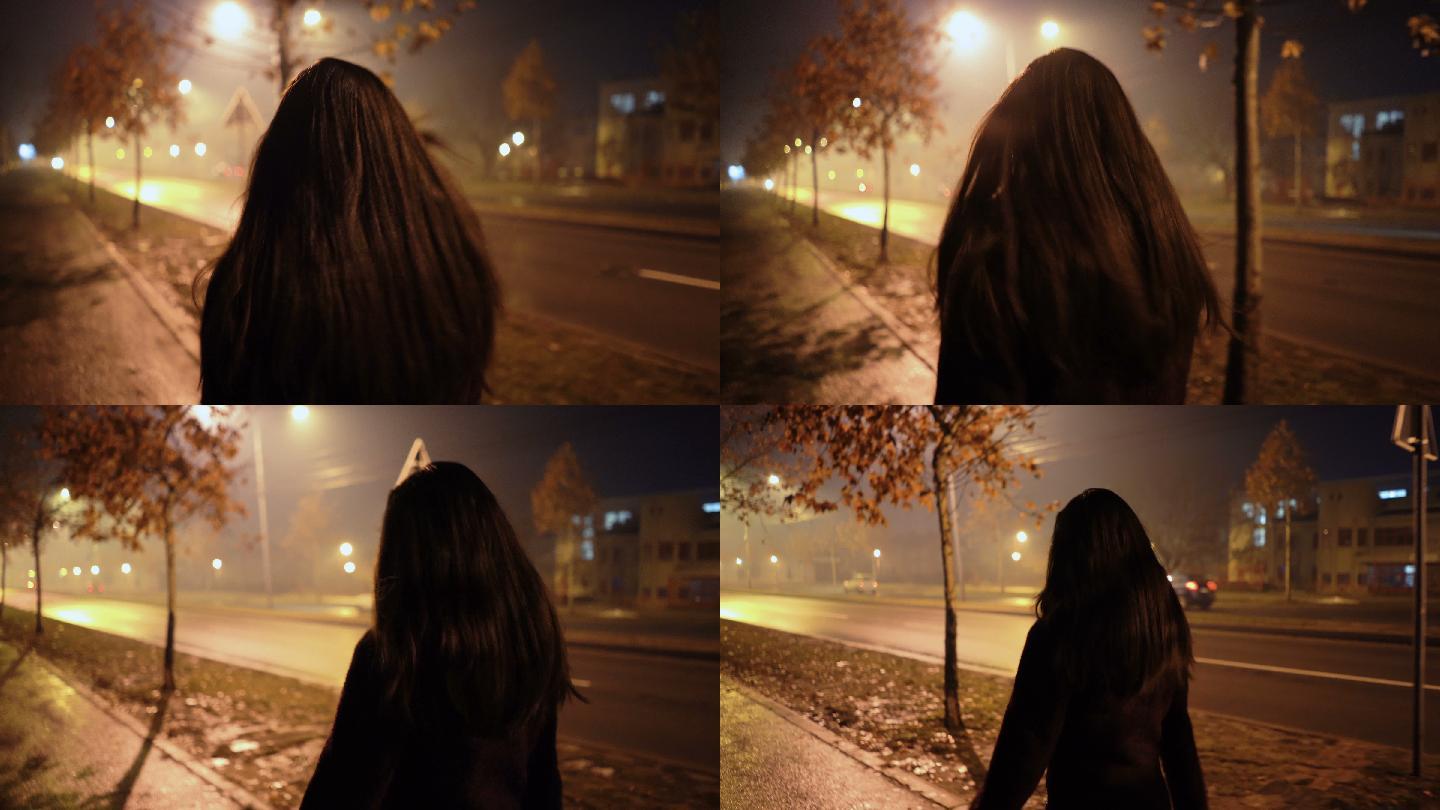 在一个雾蒙蒙的夜晚年轻女子在街上走着