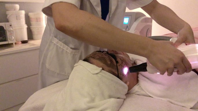 女性在美容院接受激光面部治疗