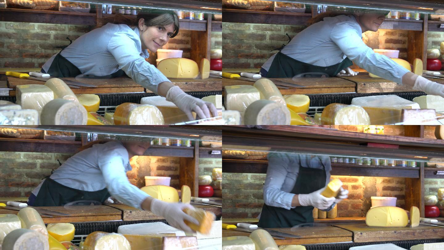 一家熟食店的老板正在摆放奶酪展示