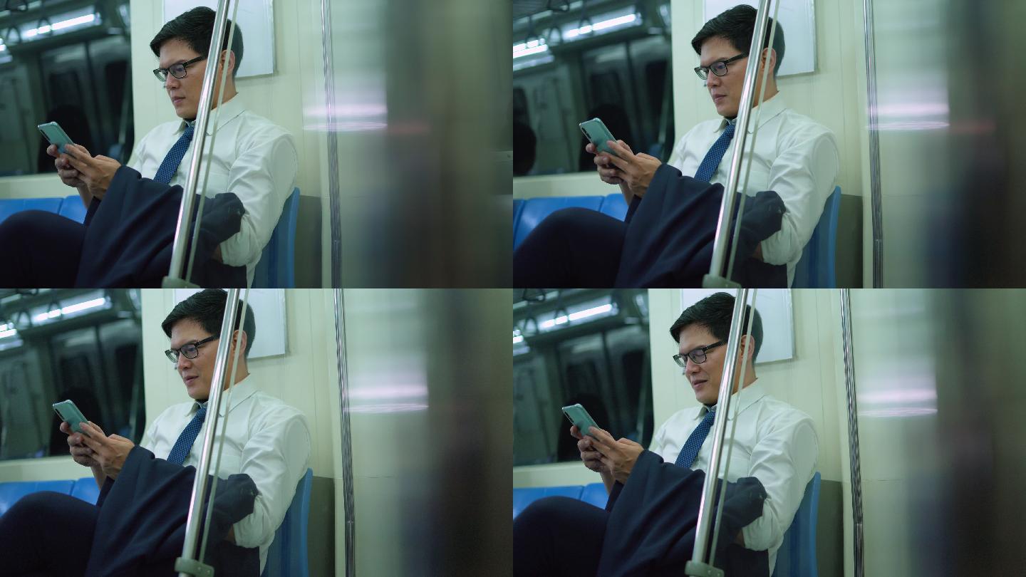 微笑的男性通勤者在地铁里用手机发短信