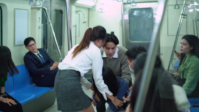 地铁乘客的帮助晕倒的妇女