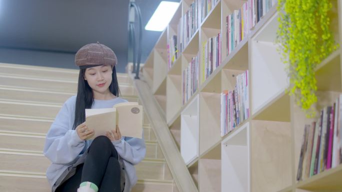 时尚漂亮女孩坐在楼梯读书