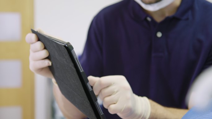 牙医通过数字平板电脑向患者介绍病情