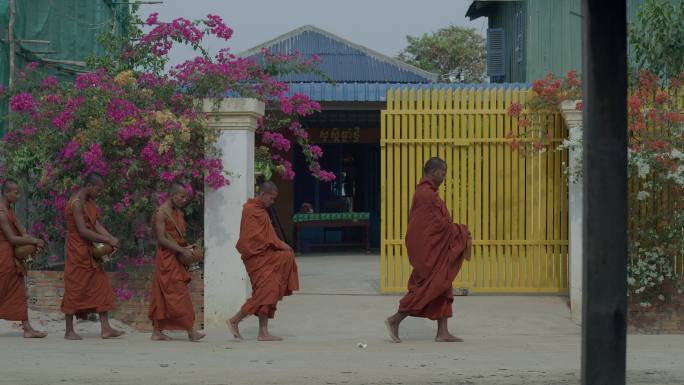 柬埔寨乡村的和尚走出寺庙去收布施