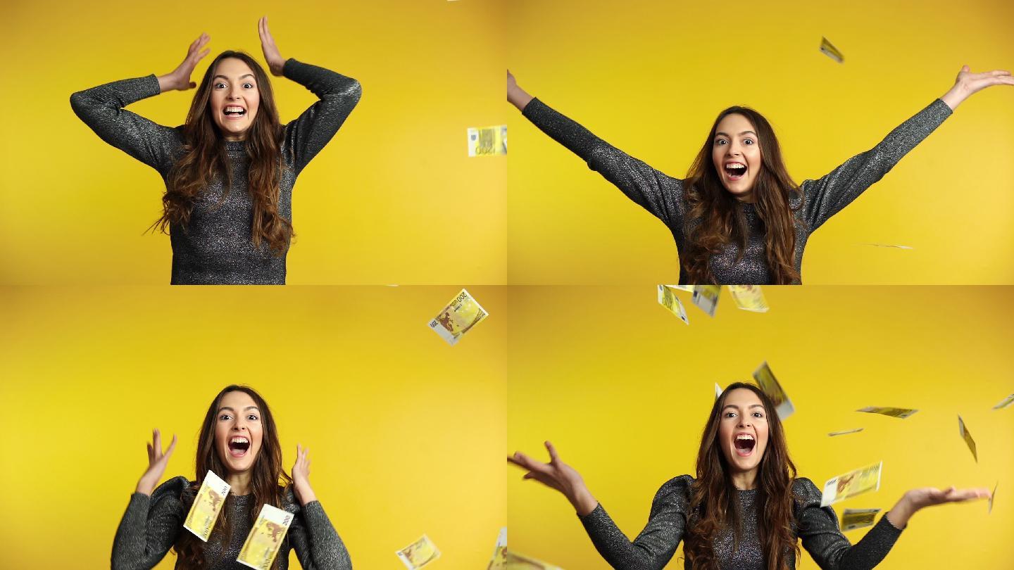 惊讶的快乐的女人站在钱雨下，钞票掉了下来