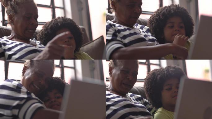 孙子抱着奶奶在家里看笔记本电脑