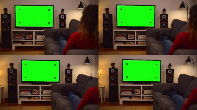 妇女在家看彩色键绿色屏幕电视