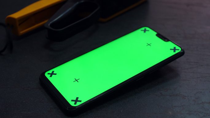 车间工作台上带绿色屏幕的手机