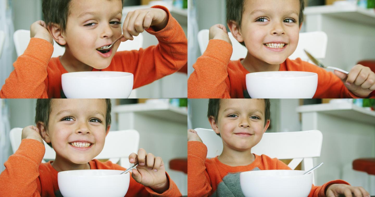 男孩在室内厨房餐桌上用勺子从碗里吃通心粉