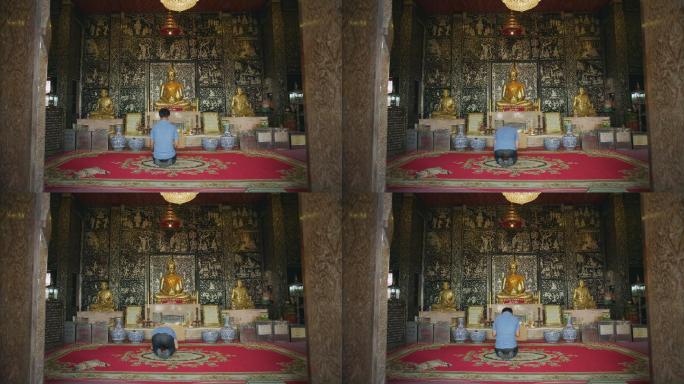泰国曼谷街边寺庙里祈祷拜佛的男人