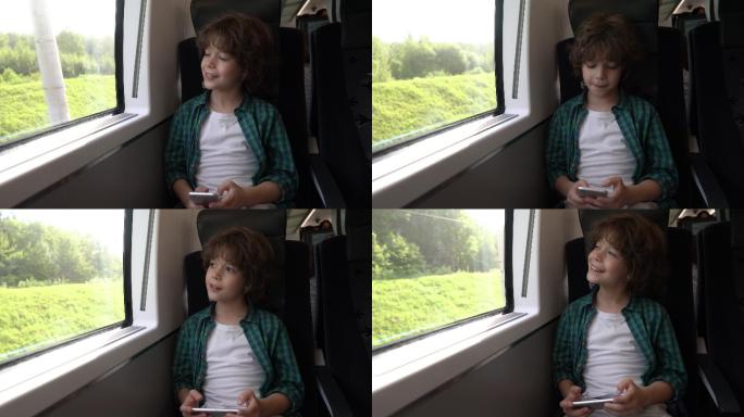 快乐的小男孩在火车上玩手机游戏