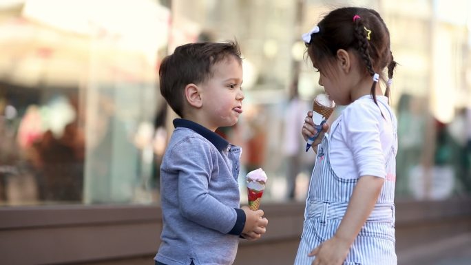 可爱的孩子们在商场前分享冰淇淋