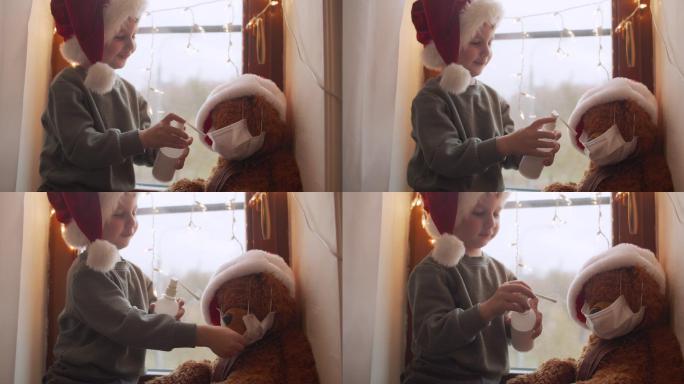 小男孩在圣诞节和他的泰迪熊玩扮演医生游戏