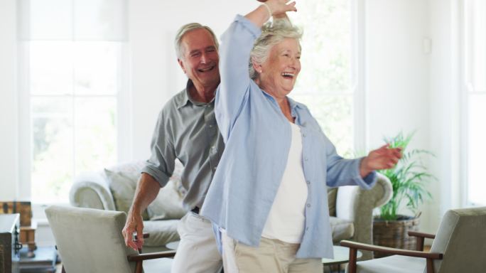 一对快乐的老年夫妇在家跳舞