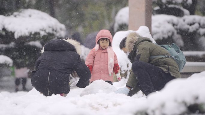 幸福一家三口雪地里玩雪堆雪人