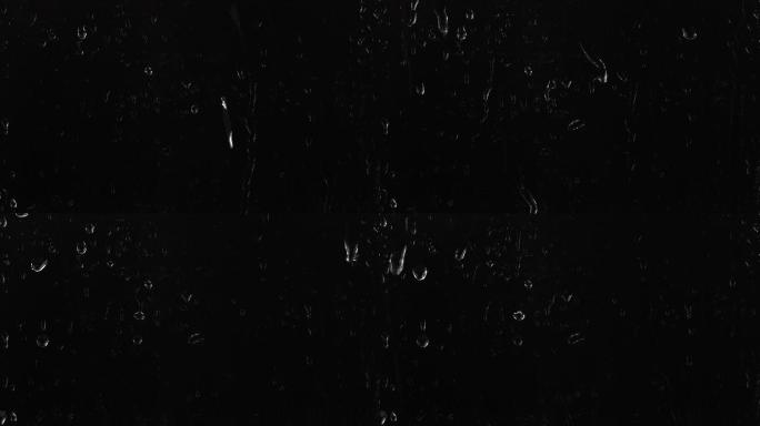 雨滴落在黑色背景上的窗户玻璃上