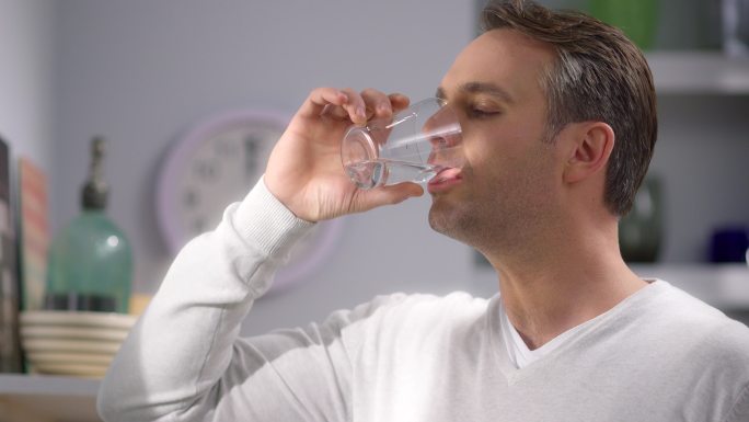 年轻人在饮用水男人喝水健康生活干净男人
