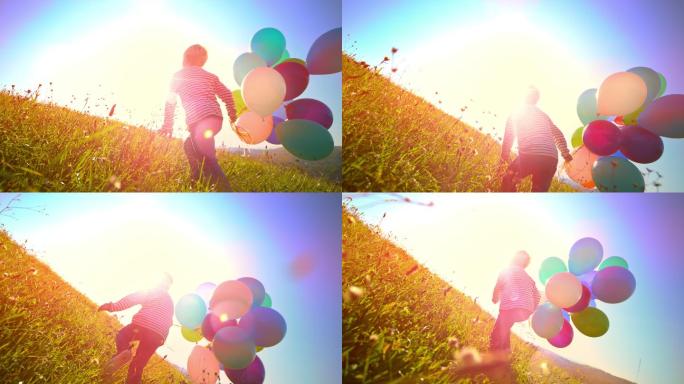 男孩拿着气球跑过阳光充足的草地