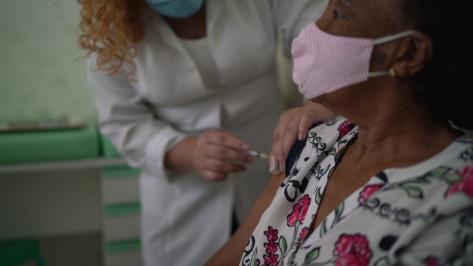 护士在病人手臂上注射疫苗