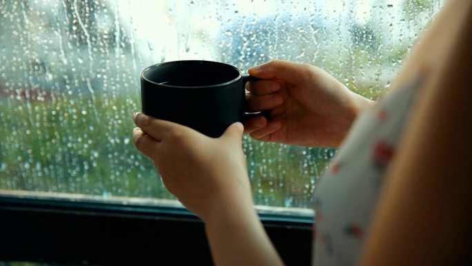 雨天在窗前喝咖啡的女人