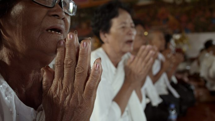 柬埔寨农村寺庙里念经祈祷的老人