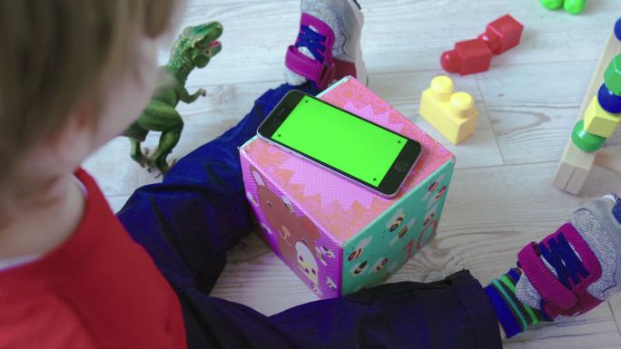 看绿色屏幕智能手机的幼儿