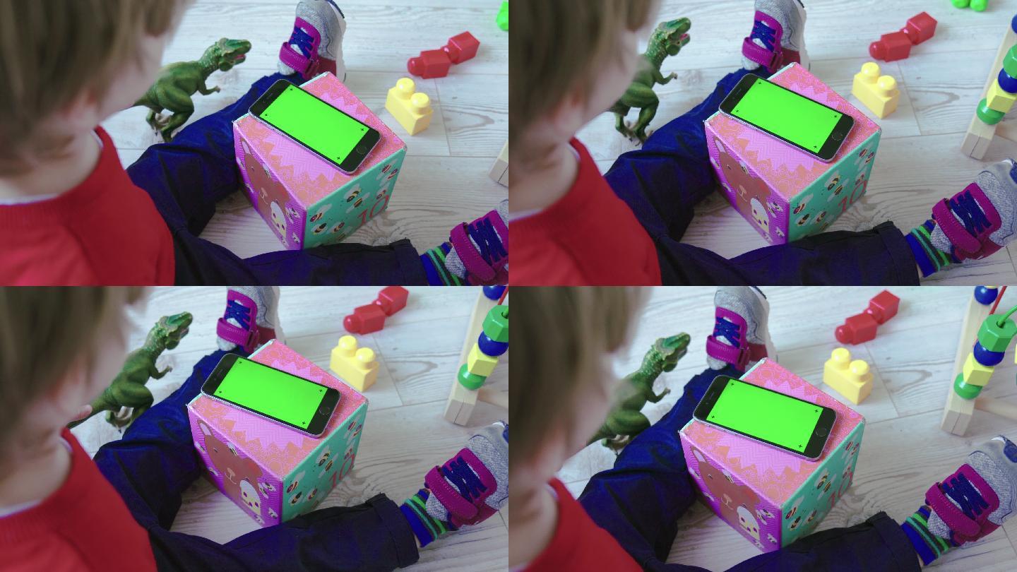 看绿色屏幕智能手机的幼儿