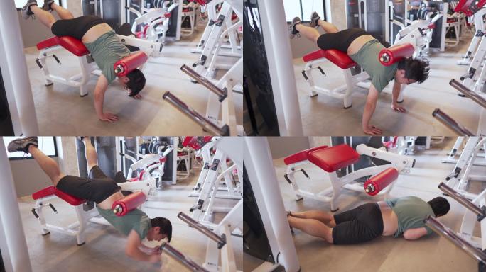男子在健身房用腿部练习机做俯卧撑