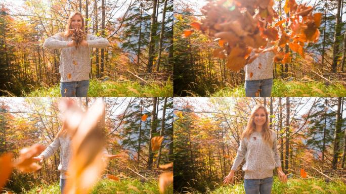公园里的女人微笑着向镜头扔秋叶