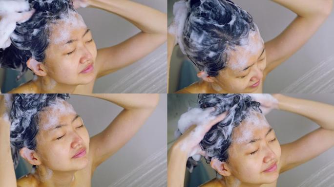 一位年轻的妇女在淋浴时洗头。