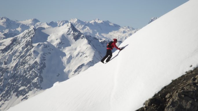 登山者爬上白雪覆盖的山