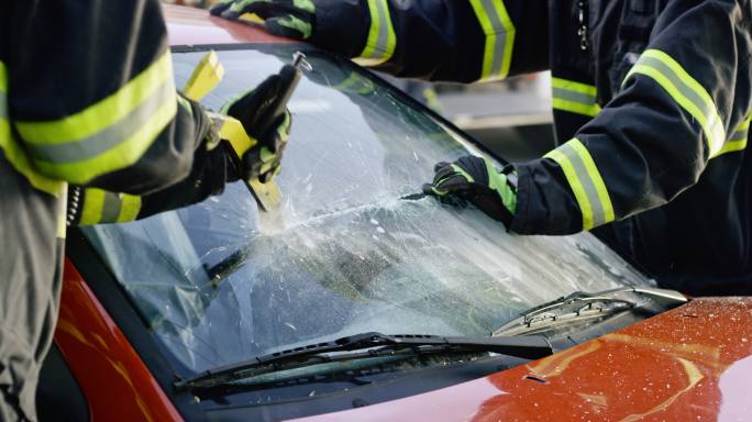 两名消防员正在切割一辆汽车的挡风玻璃