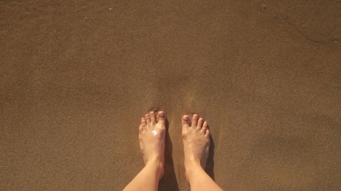 赤脚在海滩上。潮水享受生活脚丫