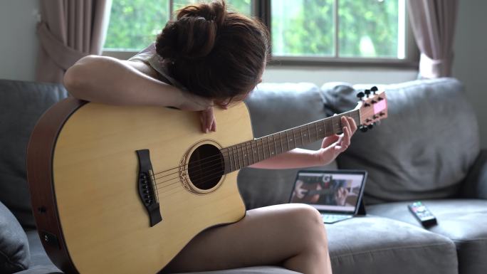 女人在家学习弹吉他