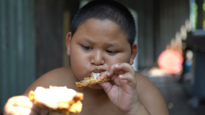 一个男孩在吃鸡肉