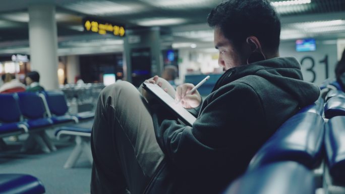 在机场使用平板电脑的男人