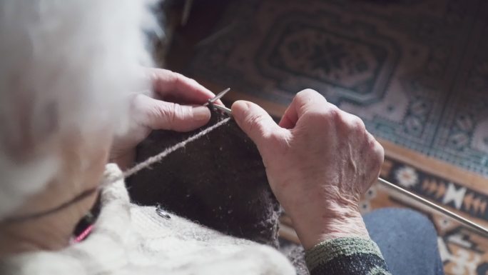 一位老年人编织冬季毛衣