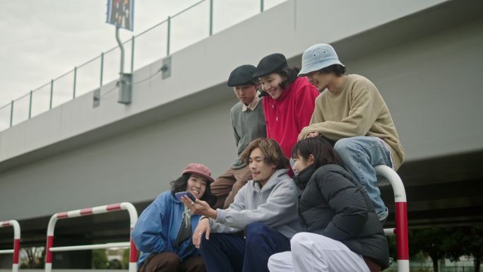一群滑板运动员在智能手机上观看视频