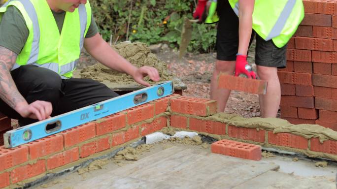 男女建筑工人用水泥砌砖