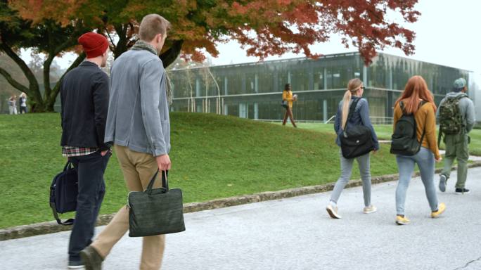 学生在校园里散步沟通-讨论相伴草