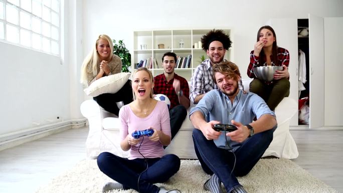 一群兴高采烈的年轻朋友在玩电子游戏