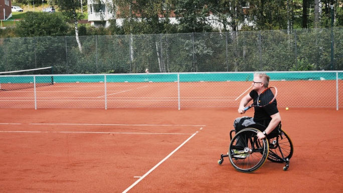 两名做轮椅男子在户外打网球