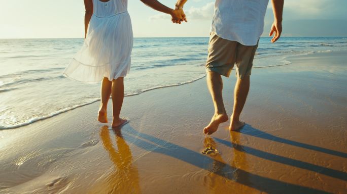情侣享受沙滩漫步新婚之旅浪漫情侣脚印足迹