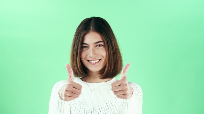 女子在绿色工作室背景下竖起大拇指