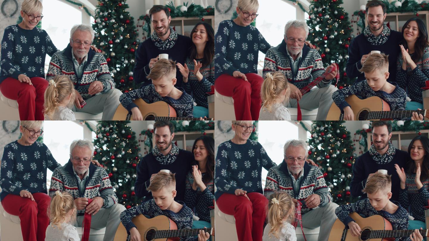 儿子或孙子在圣诞节为他们弹吉他