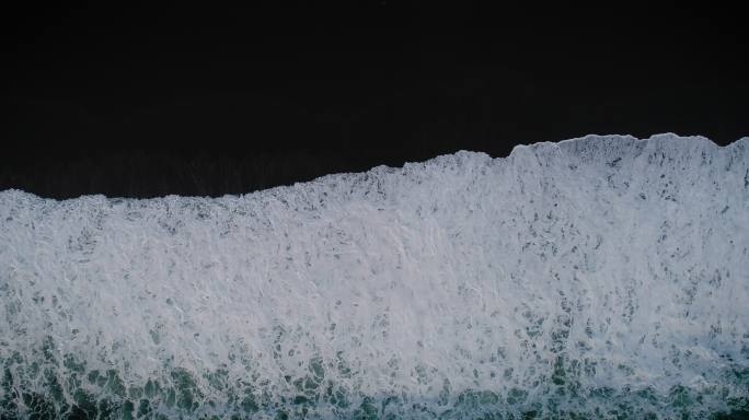 黑色沙滩上的波浪。