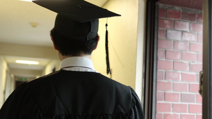 大学毕业的年轻人学士帽向前走背影