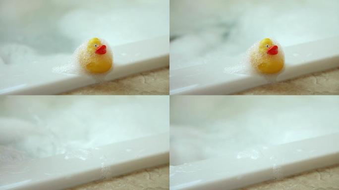 孩子从浴缸的侧面抓起橡胶鸭子
