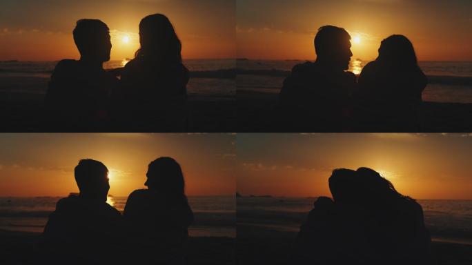 坐在海滩上的夫妇剪影逆光夕阳情侣夫妻